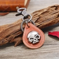 Vintage Punk Totenkopf Schlüsselanhänger aus braunem Leder auf verwittertem Holz - Hellbraun
