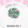 Rainbow spiral polymer clay lollipop accessory on a white plate with pink dot background - Rainbow Style 1