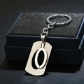 Macro detail of a brushed stainless steel letter O keychain in a premium black gift box - Letter O / Silver