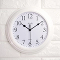 Reloj de pared blanco minimalista con números negros en una pared de ladrillo blanco - Blanco