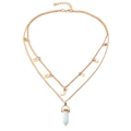Detail of layered gold necklace with star charms, moon, and white hexagonal stone pendant - Opalite