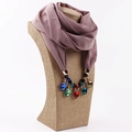 Detail of mauve chiffon scarf featuring a bold statement necklace with multi-color gems - Leather Purple