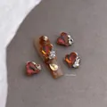 Macro detail van Maillard hart nagelbedeltjes met glanzende strassteentjes, 10x10mm - 10x10mm Donkerbruine Hartstijl (Maillard 2564)