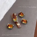 Macro-opname van een 13x10mm amber kristallen nagelbedel met parels en strass - 13x10mm Rechthoekige Stijl (Maillard 2565)