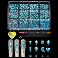 Macro view of 12-grid light blue nail art rhinestones with tweezers and picker pen tools - 12 Grids Lake Blue Rhinestone Set