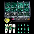 Detail view of emerald green nail art rhinestones kit with wax pen and tweezers on black background - 12 Grids Green Rhinestone Set