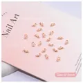 Close-up of 6x3mm apricot ribbon bow nail charms with silver micro beads for nail art - Apricot Bowknot (2507) / 6*3mm