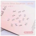 Detailed macro view of a 8x4mm white ballet bow nail art charm with a center pearl bead - White Bowknot (2509) / 8*4mm Through Hole Bead