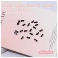 Macro shot of black ribbon bow nail charms with pearls, size 6x3mm for manicure art - Black Bowknot (2513)