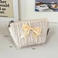 Cream tweed makeup bag with yellow silk bow and Mila Bliss brand label for travel - Small White Hexagonal Bag