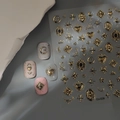 Macro detail of 3D embossed gold cross and moon nail stickers on various polish colors - Heart Star Cross (CO-526) / Gold