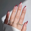 Pear-cut gold ring set with sparkling stones shown with festive red and white nails - Pear Cut Gold Open Diamond Ring Style (XH-13-03)