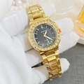 Detail of gold square watch with rhinestone bezel and textured grey dial held by hand - Gold Black