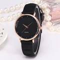 Minimalist quartz watch with rose gold case and black silicone strap on elegant background - Black