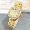Detail view of square gold quartz watch with rhinestone bezel and textured dial on pearls - Gold