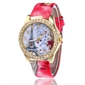 Detailed view of the Eiffel Tower and heart pattern on a gold rhinestone watch face - Red