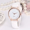 Flache Quarzuhr mit Roségoldgehäuse und weißem Silikonarmband auf elegantem Hintergrund - Weiß