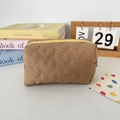 Detailed shot of brown quilted heart cosmetic bag with a vibrant yellow zipper closure - Quilted Heart Brown