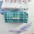 Macro shot of blue checkered fabric pencil case with May Rabbit woven label - Cadmium Green Plaid