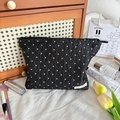 Détail de la trousse de maquillage noire à pois avec tissu texturé et étiquette tissée - Grand / Pois Noir