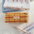 Detail of checkered orange pencil case with top zipper and woven May Rabbit label - Orange Grid