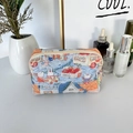 Detailed macro view of quilted makeup bag with cute cartoon rabbit prints and top zipper - Rabbit Family