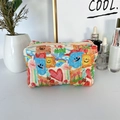 Quilted cosmetic bag detail featuring colorful bear and tulip patterns on desktop - Graffiti