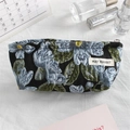 Detail of floral embroidery on a black canvas pouch with calendar and skincare accessories - Blue Floral