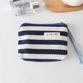Close-up of navy striped canvas coin purse with hand strap and woven herringbone texture - Navy Stripe