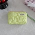 Detail of light green quilted mini pouch featuring yellow zipper and woven wrist strap - Quilted Cloud Light Green