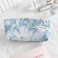 Flat lay of mini floral embroidered canvas makeup bag with small white daisy patterns - Blue White Floral