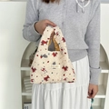 Close-up of cream quilted puff tote bag with puppy patterns and yellow plaid lining - Cream Dog (Seersucker)