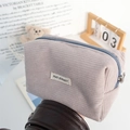 Detail of soft corduroy fabric texture and zipper closure on the purple storage pouch - Gray
