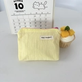 Dettaglio della borsa in nylon impermeabile a quadretti gialli con cerniera rosa e logo - Giallo