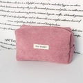 Detail of pink corduroy stationery bag with silver zipper pull and white fabric label - Lotus Pink