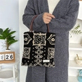 Dettaglio della borsa tote in peluche con motivo geometrico e manici in pelle scura - Totem nero etnico