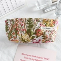 Close-up of floral embroidery on a compact canvas makeup bag with metallic zipper - Abundant Flowers