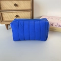 Macro shot of bright blue quilted nylon texture and zipper detail of the makeup bag - Quilted Vertical Stripe Royal Blue
