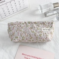 Close-up of floral canvas pouch with pink flower embroidery and branded woven label - Pink Green Floral