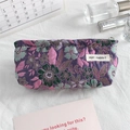 Detail of floral embroidery fabric and brand label on a purple jacquard canvas pouch - Purple Floral