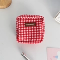 Macro detail of red and white plaid fabric mini pouch with a brown leather logo patch - Woolen Red Gingham (Leather Label)