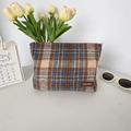Detalle del neceser vintage de cuadros con textura de tweed y etiqueta de cuero - Lana Cuadros Azul
