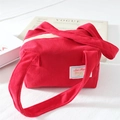 Detail of red corduroy handbag showing soft ribbed texture and elegant white logo label - Red Corduroy
