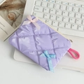 Dettaglio della borsa trapuntata lavanda con fiocchi di raso su tastiera di laptop - Quadretti Viola Chiaro