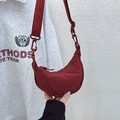 Detail of red water-resistant nylon crescent crossbody bag with adjustable wide strap - Burgundy