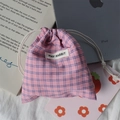 Flat lay of pink plaid drawstring organizer bag for makeup and small accessories - Blue Pink Plaid