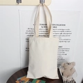 Detail showing the thick blank canvas tote bag in a minimalist indoor setting - 12oz / White