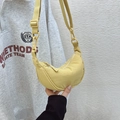 Detail showing light yellow crescent crossbody bag with adjustable strap in hand - Light Yellow