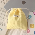 Close-up of yellow waffle fabric drawstring bag for cosmetics on a desk with laptop - Polyester Waffle Yellow