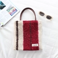 Detail of plush tote bag with colored stripes, leather handles and brand label - Red and Brown Striped
